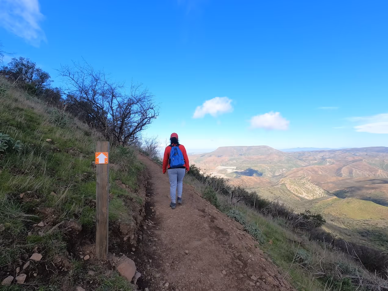 Senderista subiendo por el terreno rocoso del Cerro del Coronel